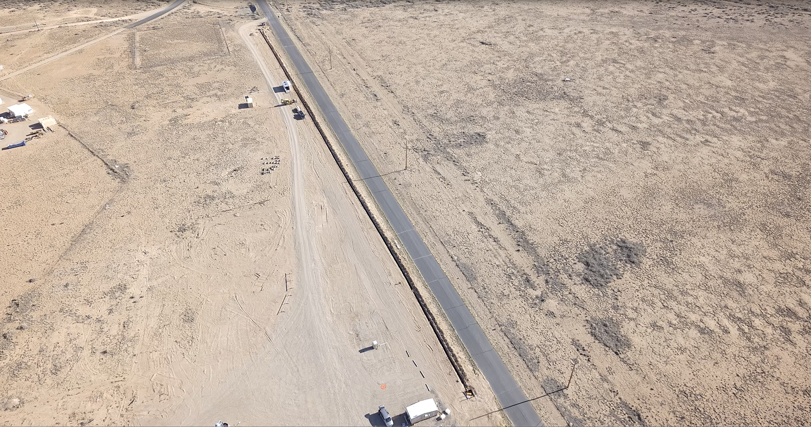 A long pipe extends along a dessert road.