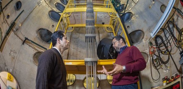 Efrain O’Neill, left, an electrical engineering professor at the University of Puerto Rico, Mayagüez, who is spending a year working at Sandia, talks energy research with senior manager Tito Bonano. (Photo by Randy Montoya)