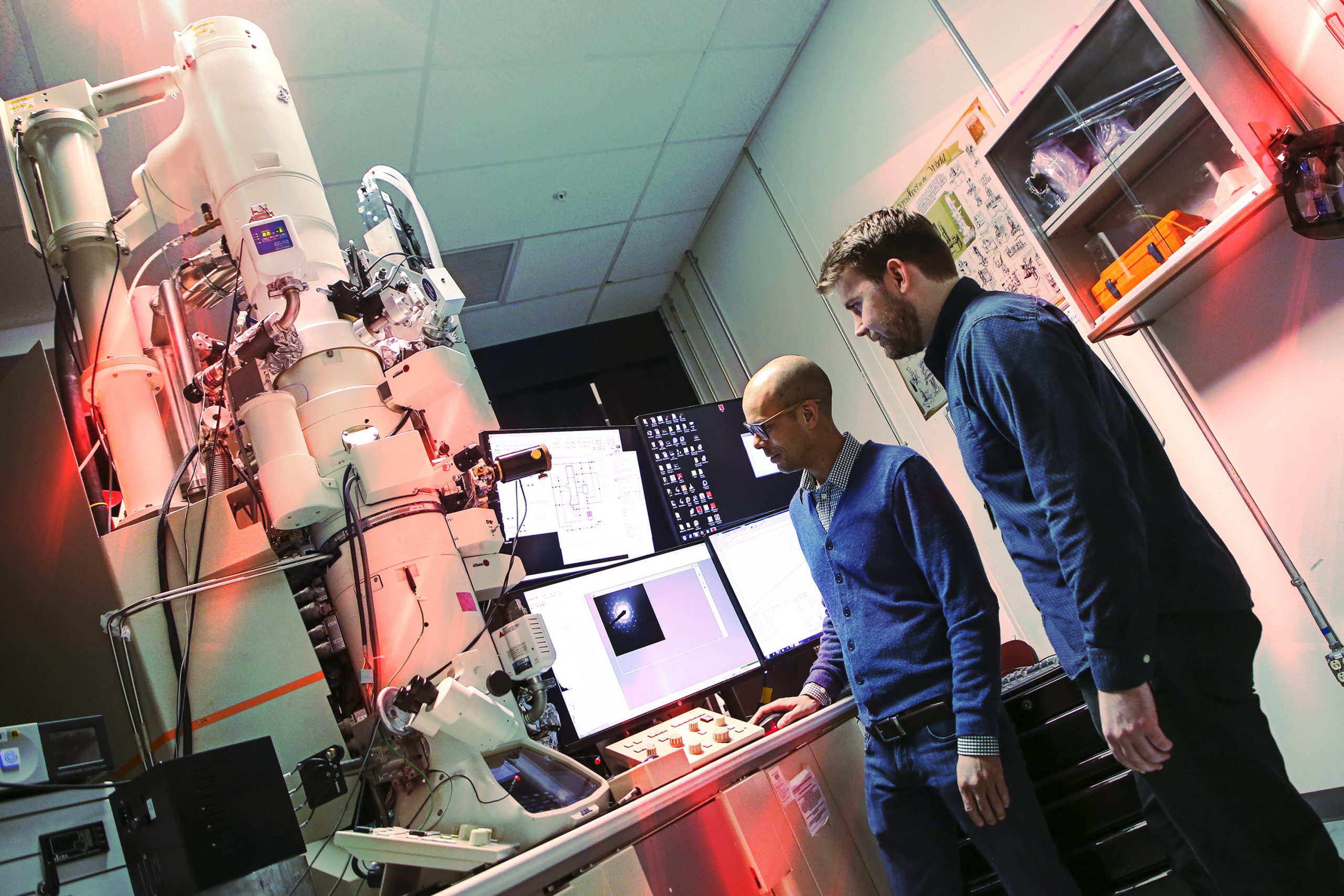 In this photo from 2020, Christopher Barr, right, a former Sandia National Laboratories postdoctoral researcher, and University of California, Irvine, professor Shen Dillon operate the In-situ Ion Irradiation Transmission Electron Microscope. Barr was part of a Sandia team that used the one-of-a-kind microscope to study atomic-scale radiation effects on metal. (Photo by Lonnie Anderson)