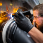A technologist operates additive manufacturing equipment