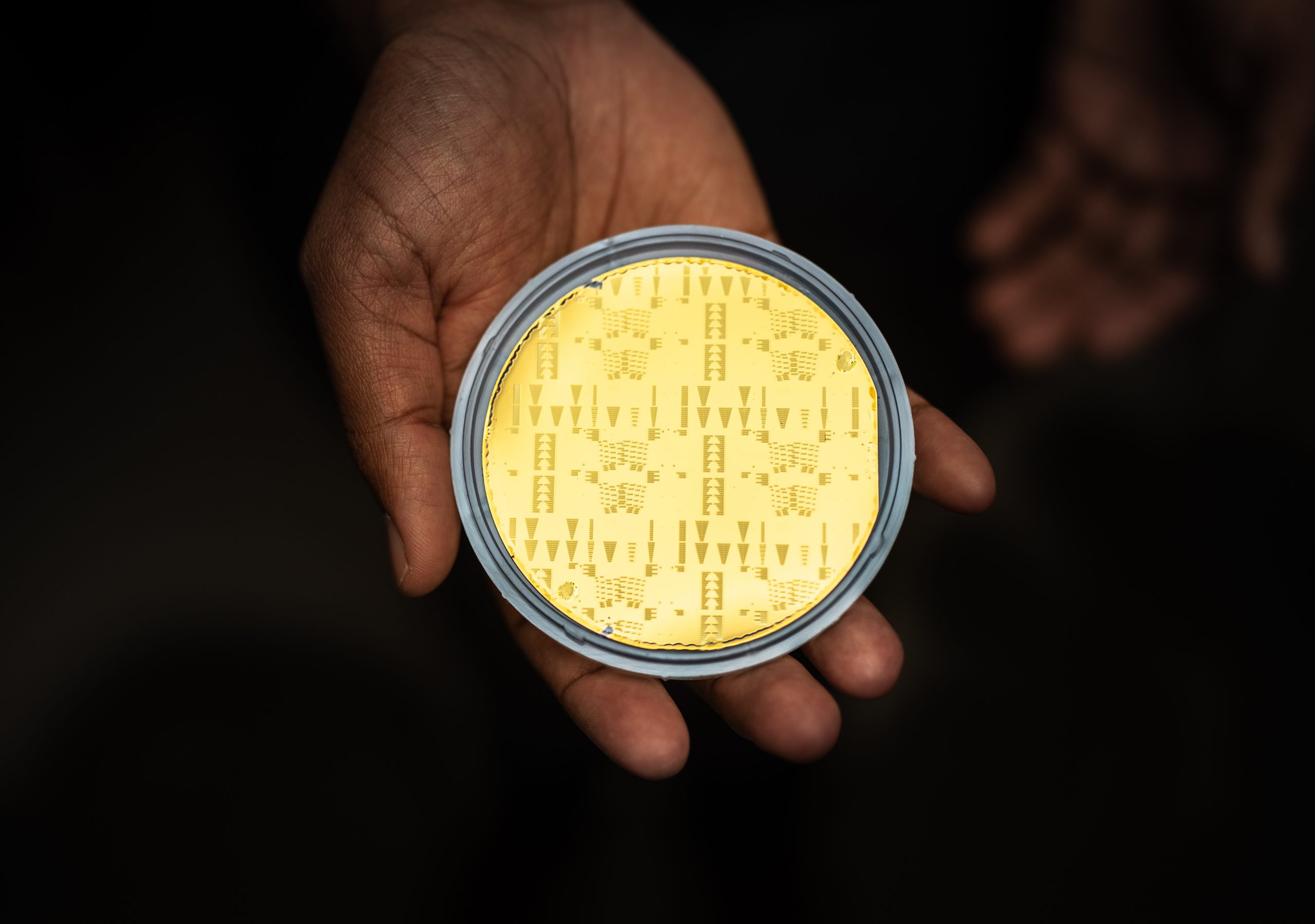 Ashok Kodigala holds a gold plated wafer filled with thousands of minute lasers made at Sandia National Laboratories MESA facility.