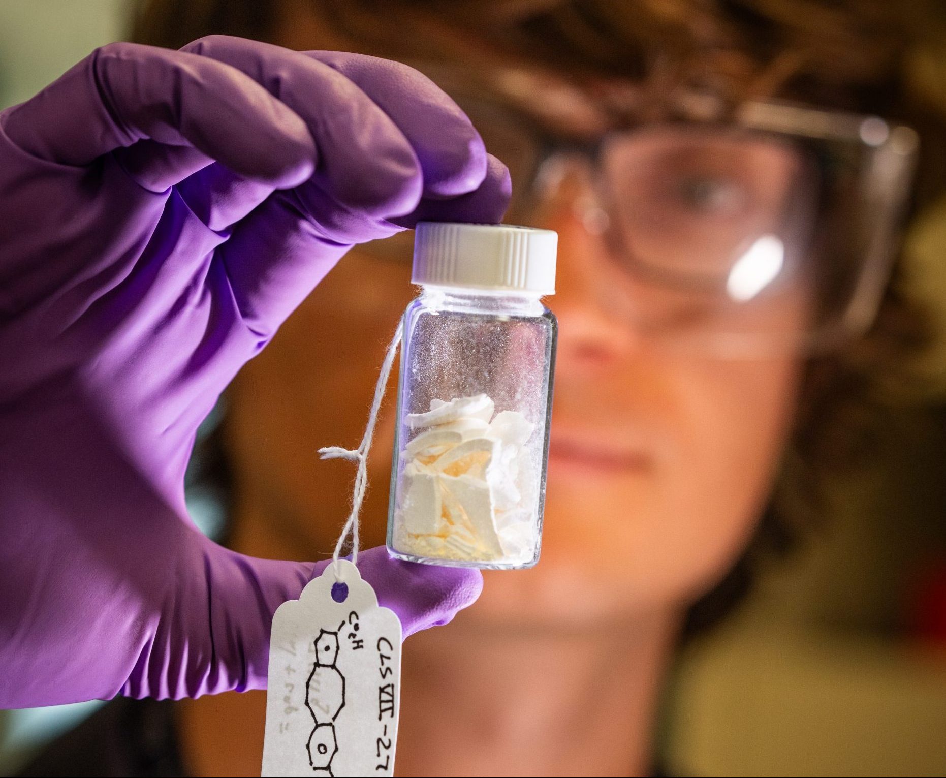 A researcher holds a vial of a new batch of a new, more durable material
