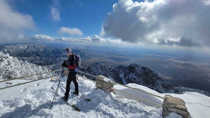 A woman on skis on top of a snowy mountain